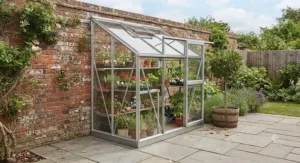 Durable aluminium frame lean-to greenhouse positioned on a patio, ideal for year-round weather protection in the UK.