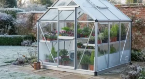 A winter-ready best aluminium greenhouse protecting potted plants and herbs from British frost